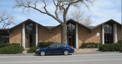 A car parked in front of a brick municipal building